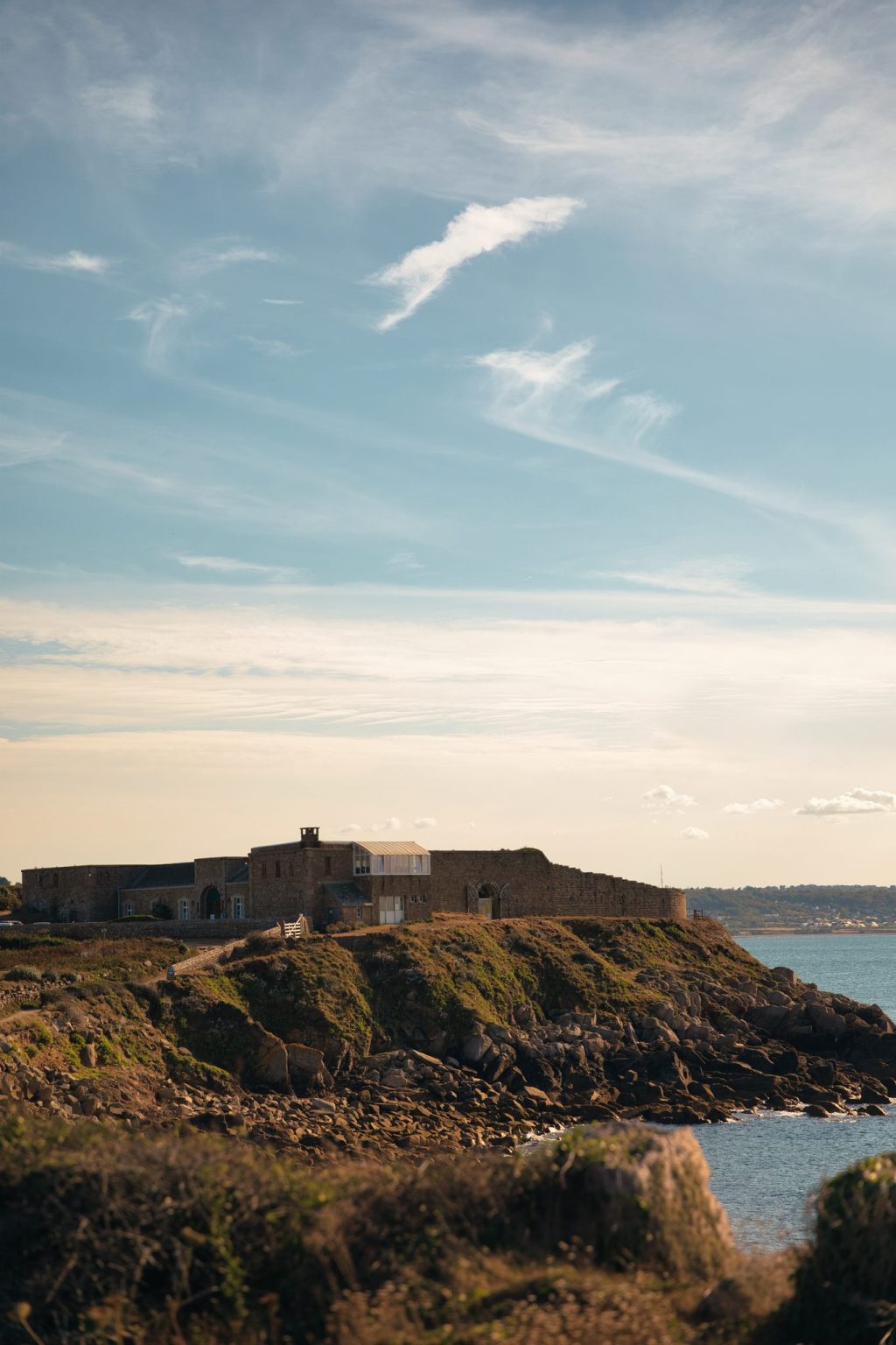 Fort de pierre sur une pointe rocheuse de la côte du Cotentin, dans la lumière dorée de fin d'après-midi