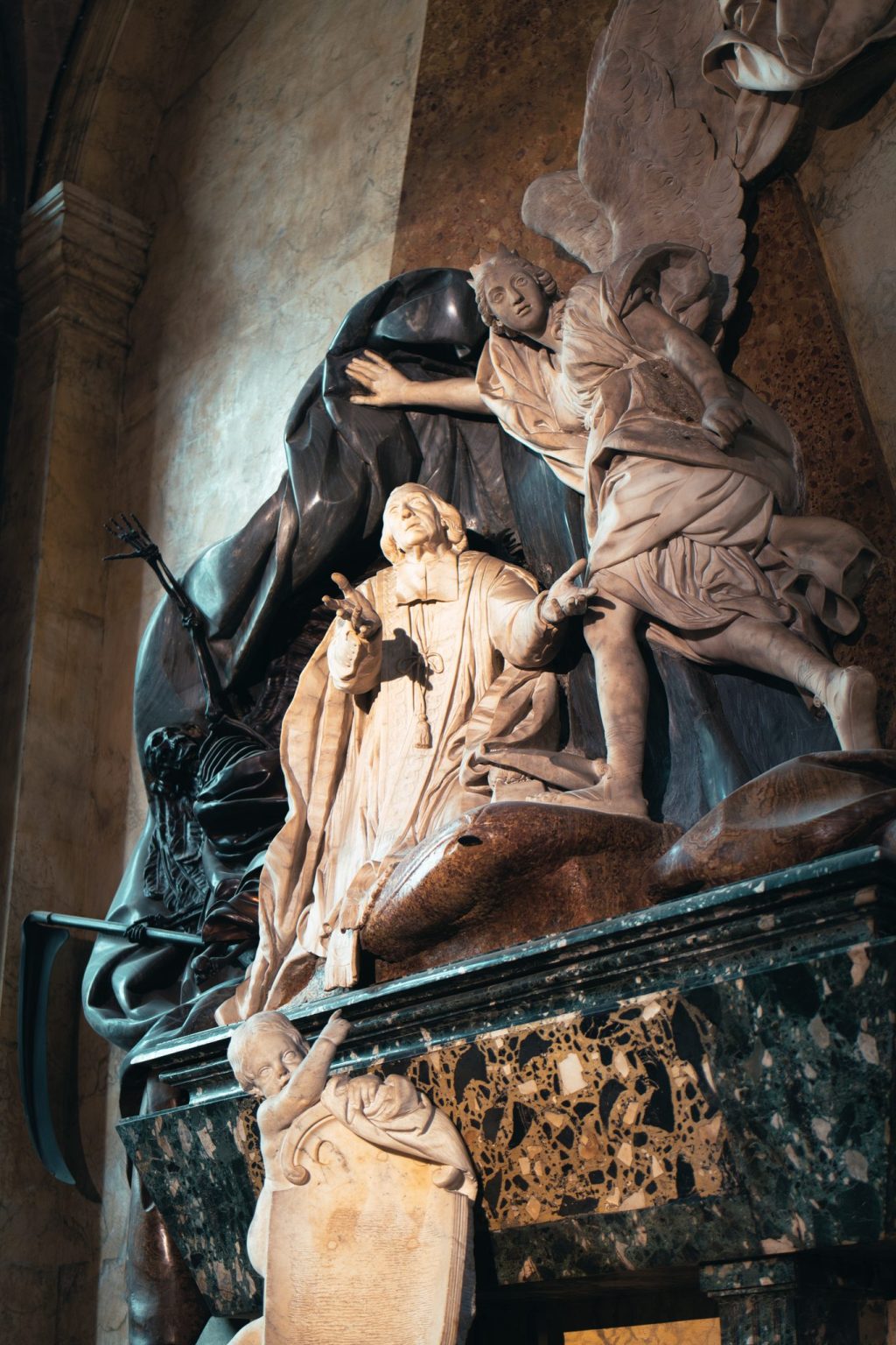 Monument funéraire baroque en marbre : un ange écarte le drap de la Mort devant le curé Languet de Gergy, en l'église Saint-Sulpice