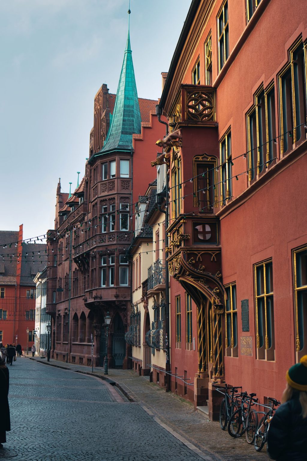 Rue pavée bordée de façades rouges à oriels sculptés et dorés dans la vieille ville de Fribourg-en-Brisgau, en Allemagne