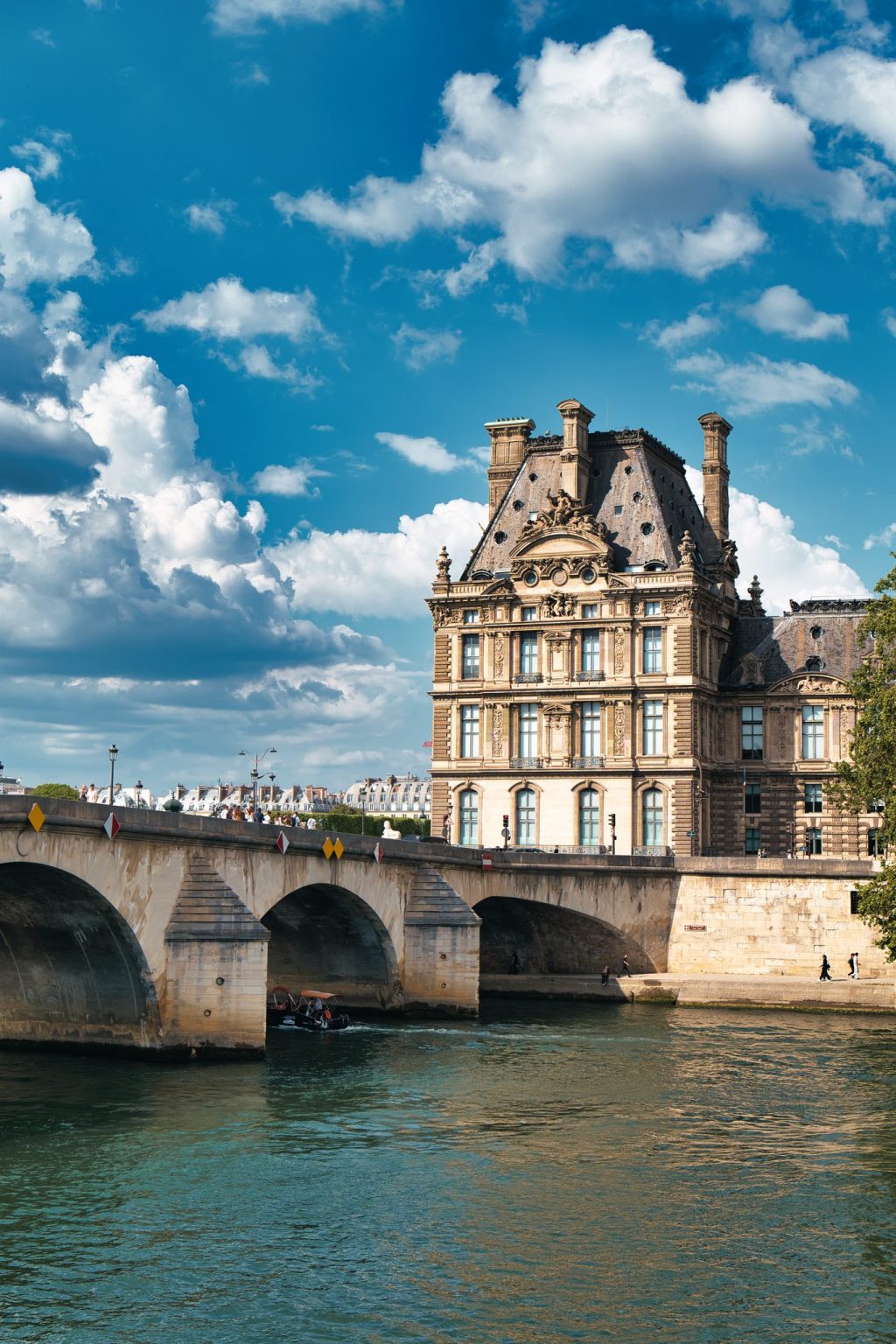 Le pavillon de Flore du Louvre et le pont Royal sur la Seine sous un ciel de nuages blancs, à Paris