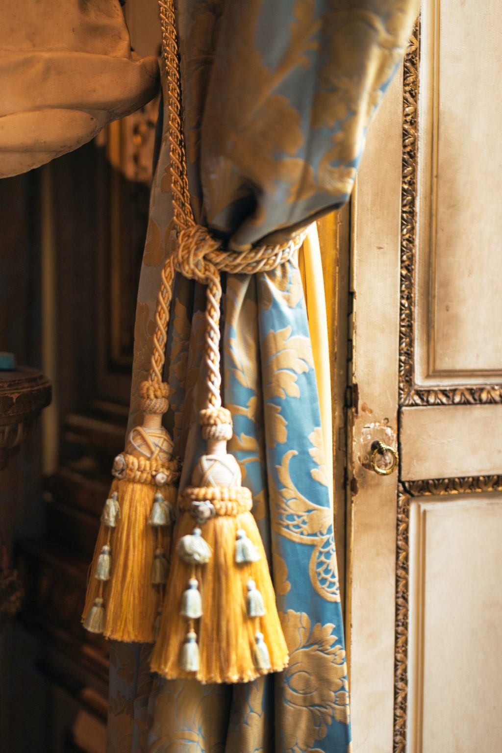 Embrasses à glands dorés retenant un rideau de soie bleue damassée, dans un salon du musée Jacquemart-André