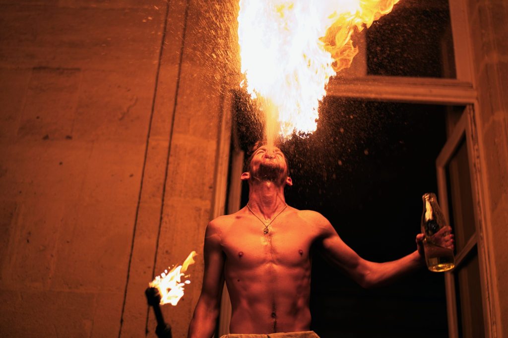 Cracheur de feu lançant une gerbe de flammes lors du spectacle historique de Siècles en scène à Sées